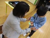 園長が新しい名札を5歳児に渡している様子