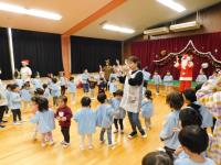 サンタクロースと一緒にジングルベルを踊る子ども達